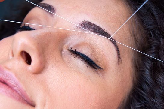 A customer reviving eyebrow threading treatment.
