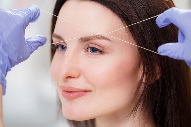 A customers receiving eyebrow threading treatment.